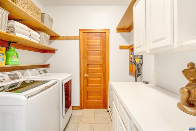 washroom featuring washer and dryer, light tile patterned floors, and cabinets