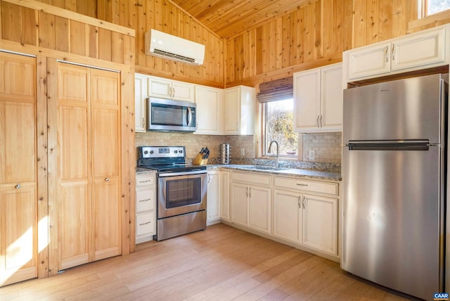 kitchen featuring a healthy amount of sunlight, wooden walls, stainless steel appliances, and an AC wall unit