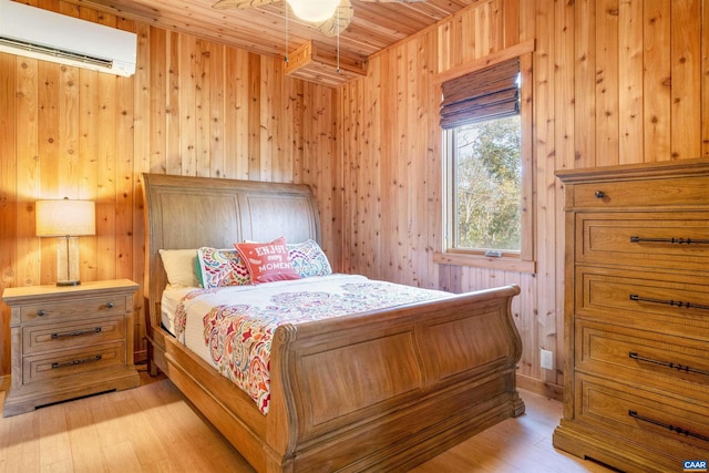 bedroom with a wall mounted air conditioner, wood ceiling, wooden walls, and light hardwood / wood-style flooring