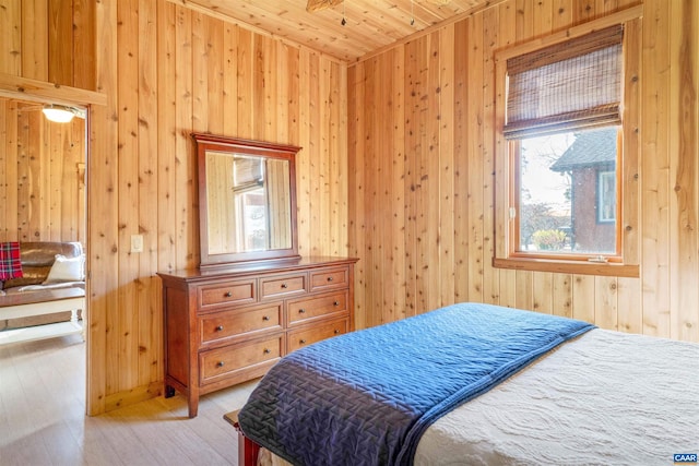 bedroom featuring wood walls, wooden ceiling, and light wood-type flooring