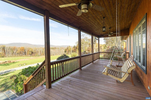 wooden deck featuring a mountain view, ceiling fan, and covered porch