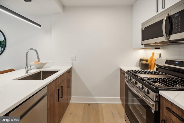 kitchen featuring light hardwood / wood-style flooring, stainless steel appliances, and sink