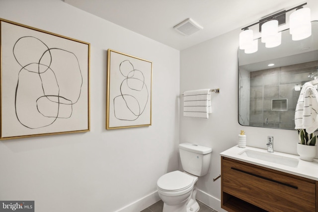 bathroom with tile patterned flooring, a shower with door, vanity, and toilet