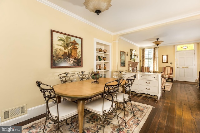 dining space featuring built in features, crown molding, and dark wood-type flooring