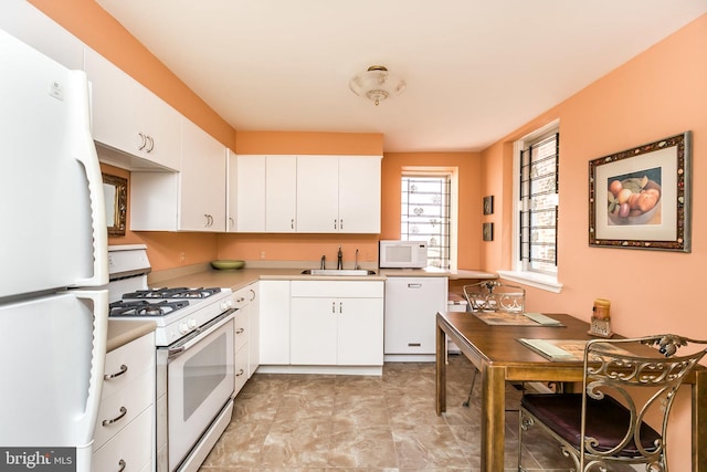 kitchen with white cabinets, white appliances, and sink