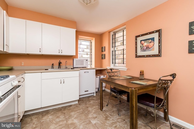 kitchen featuring white cabinets, white appliances, and sink