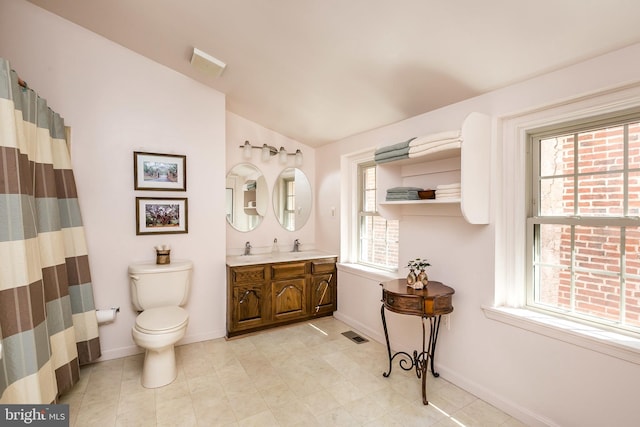 bathroom featuring vanity, lofted ceiling, and toilet