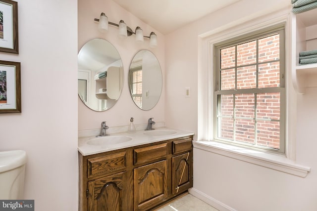 bathroom with tile patterned floors, vanity, toilet, and a wealth of natural light