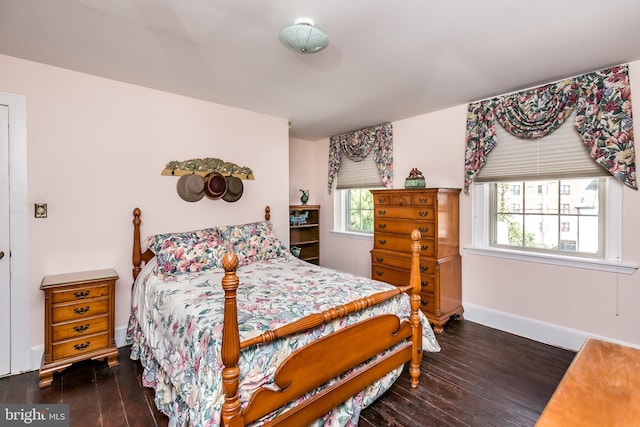 bedroom with dark hardwood / wood-style flooring and multiple windows