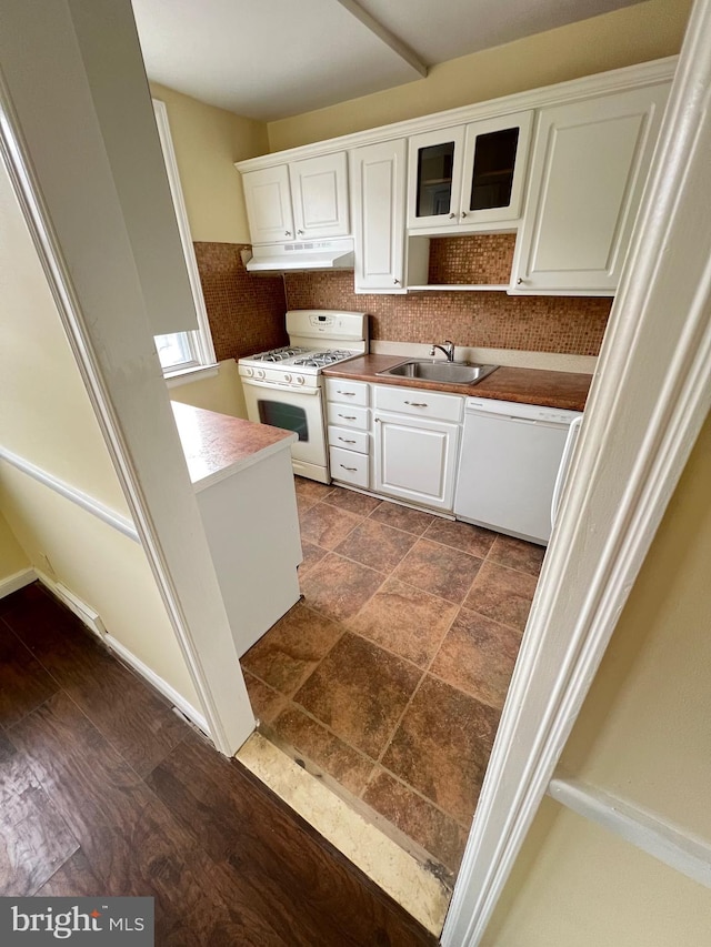 kitchen featuring backsplash, white cabinetry, sink, and white appliances