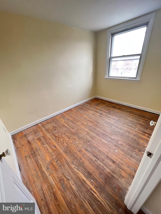 unfurnished room with dark wood-type flooring