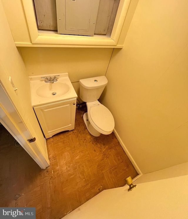 bathroom featuring electric panel, vanity, and toilet