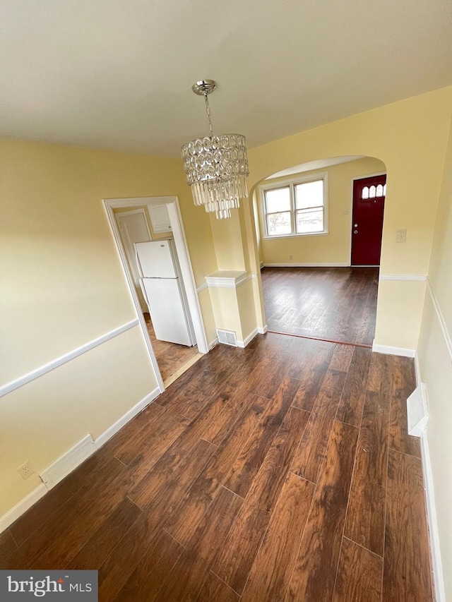 unfurnished dining area featuring dark hardwood / wood-style floors and a notable chandelier