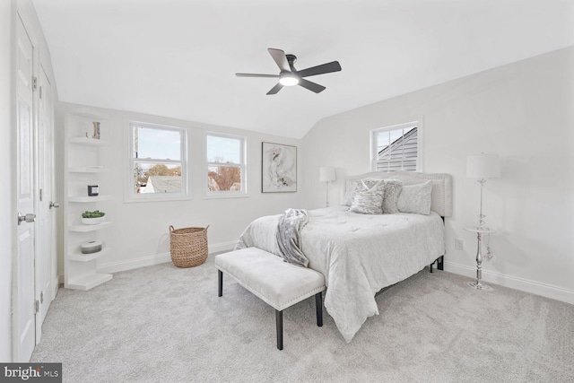 bedroom with ceiling fan, lofted ceiling, light carpet, and multiple windows