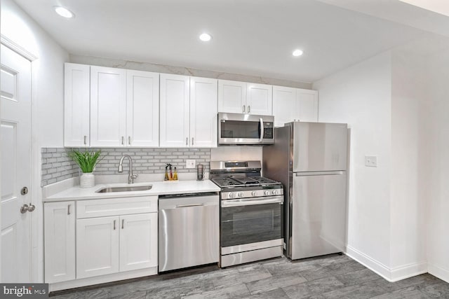 kitchen with decorative backsplash, white cabinetry, sink, and stainless steel appliances