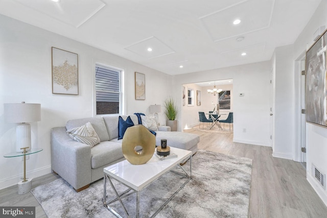 living room featuring light hardwood / wood-style flooring and a notable chandelier