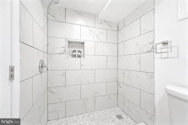 bathroom featuring toilet and tiled shower