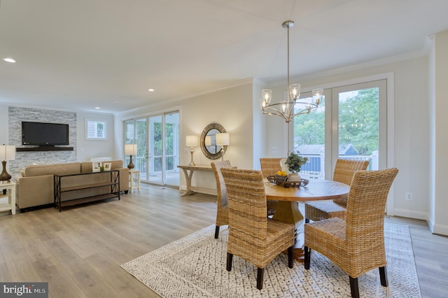 dining room featuring an inviting chandelier, light hardwood / wood-style floors, and ornamental molding