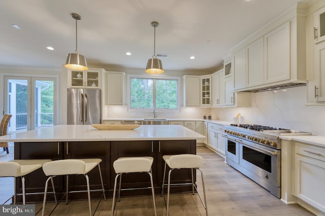 kitchen featuring a wealth of natural light, a kitchen island, light wood-type flooring, and appliances with stainless steel finishes