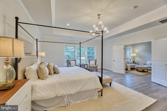 bedroom with hardwood / wood-style flooring, crown molding, and a notable chandelier