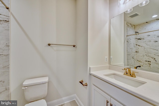 bathroom featuring vanity, toilet, and tiled shower