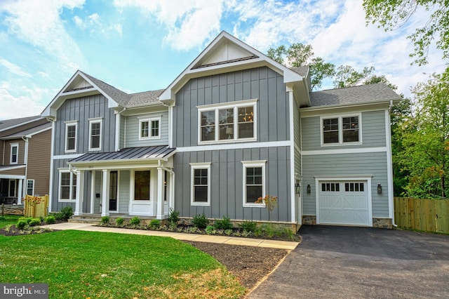 view of front of house with a porch, a garage, and a front lawn