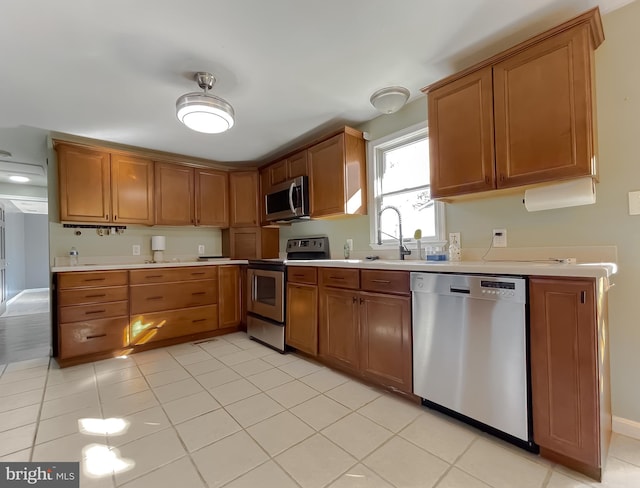 kitchen featuring sink, light tile patterned floors, and stainless steel appliances