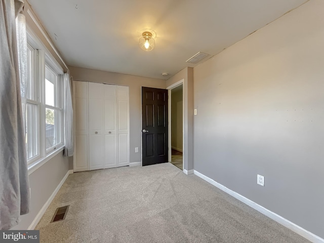 unfurnished bedroom with carpet flooring and a closet