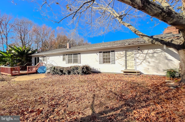 rear view of house featuring a wooden deck