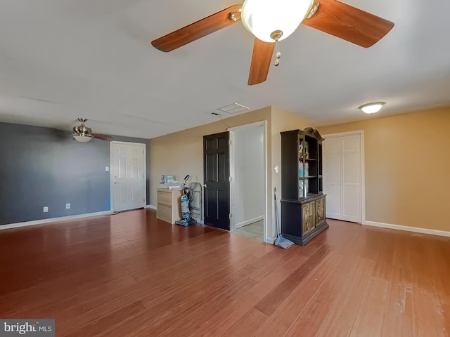 unfurnished living room featuring wood-type flooring and ceiling fan