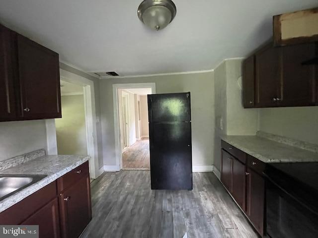 kitchen featuring crown molding, black electric range, wood-type flooring, and sink