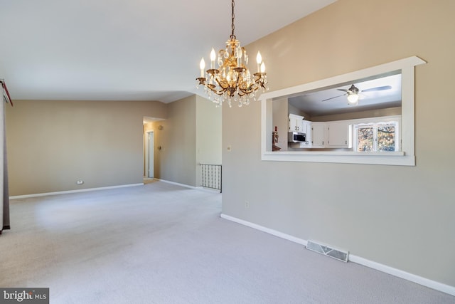 empty room with ceiling fan with notable chandelier, light colored carpet, and lofted ceiling