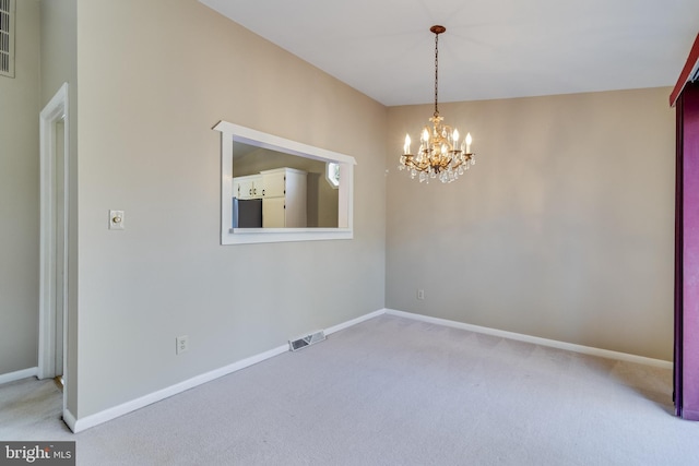 empty room with a chandelier and carpet flooring