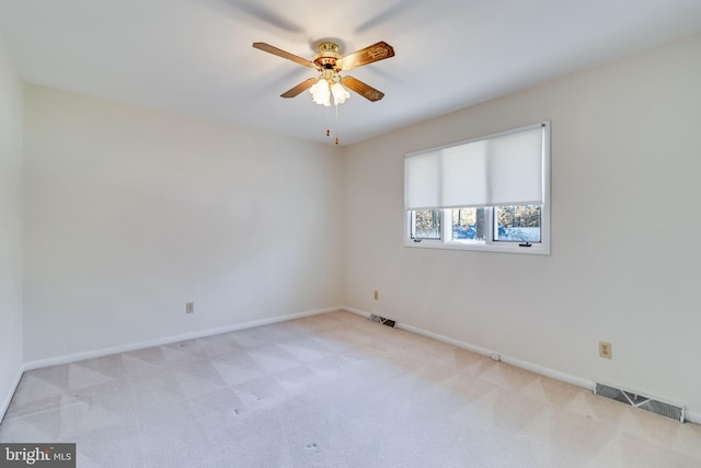 empty room featuring ceiling fan and light colored carpet