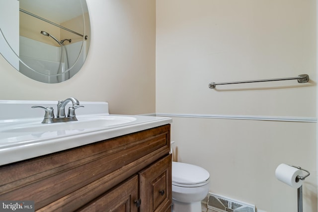 bathroom featuring vanity, toilet, and walk in shower