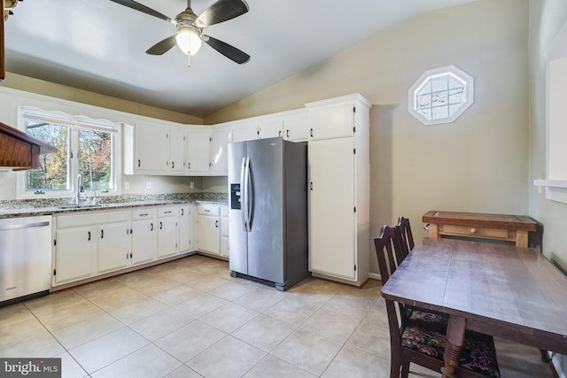 kitchen featuring stone counters, sink, stainless steel appliances, lofted ceiling, and white cabinets