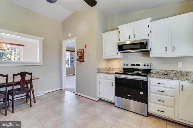 kitchen with appliances with stainless steel finishes, white cabinetry, a wealth of natural light, and lofted ceiling