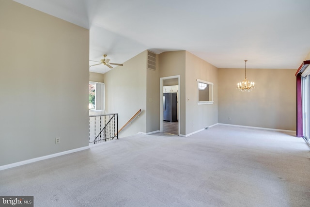 carpeted spare room with lofted ceiling and ceiling fan with notable chandelier