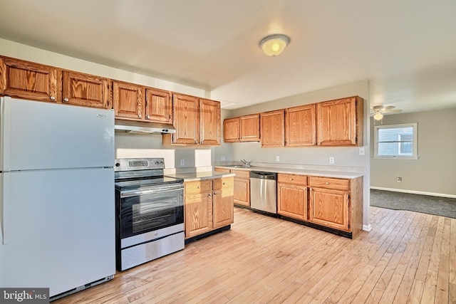 kitchen featuring ceiling fan, light hardwood / wood-style floors, sink, and stainless steel appliances