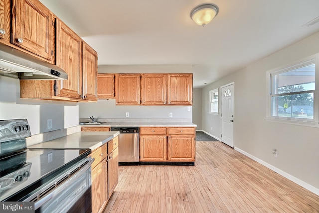 kitchen featuring stainless steel dishwasher, light hardwood / wood-style flooring, a wealth of natural light, and black / electric stove