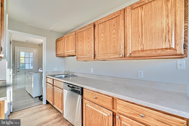 kitchen with sink, dishwasher, washer and dryer, and light hardwood / wood-style flooring