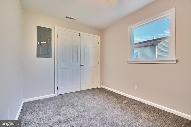 unfurnished bedroom featuring carpet floors, electric panel, a closet, and ceiling fan