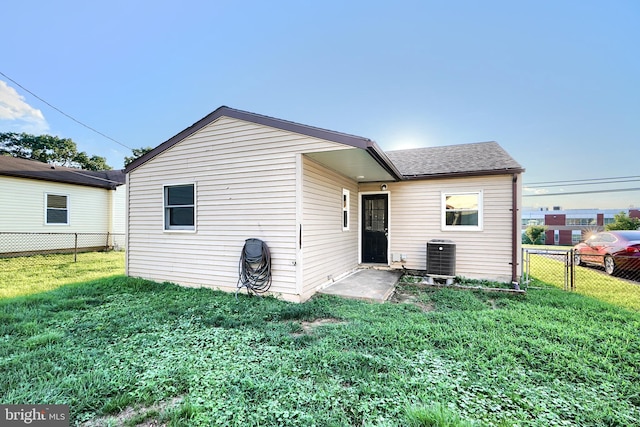 back of house featuring a lawn and central AC