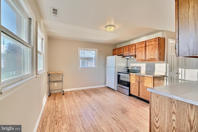 kitchen with electric range, white refrigerator, and light wood-type flooring