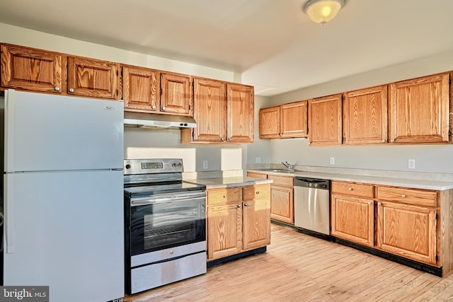 kitchen featuring sink, light wood-type flooring, and appliances with stainless steel finishes