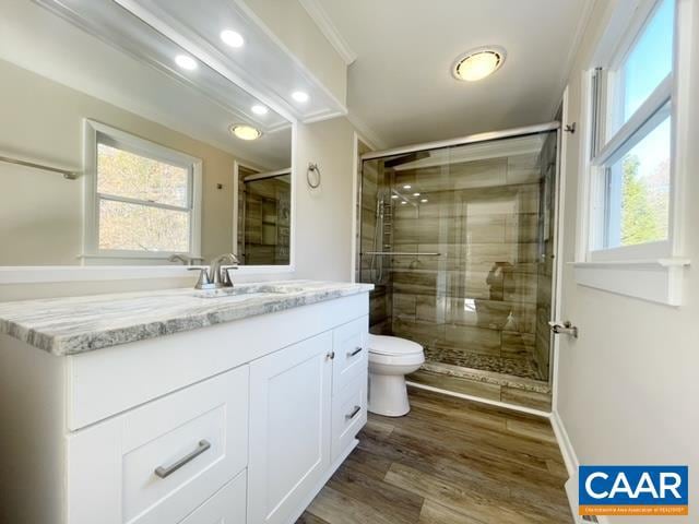 bathroom featuring crown molding, vanity, wood-type flooring, and toilet