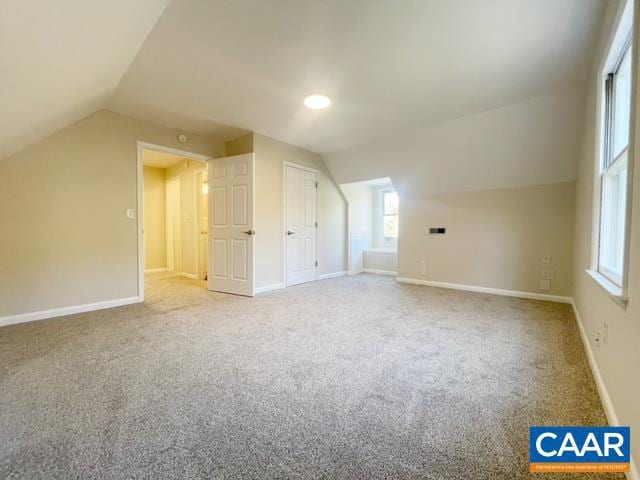 additional living space with carpet floors and vaulted ceiling