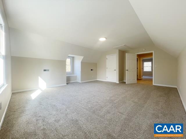 21 Zion Ct, Zion Crossroads, VA 22942 - additional living space with vaulted ceiling, carpet, healthy amount of natural light, and baseboards