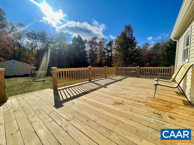 21 Zion Ct, Zion Crossroads, VA 22942 - wooden deck featuring a storage shed, an outbuilding, and view of wooded area