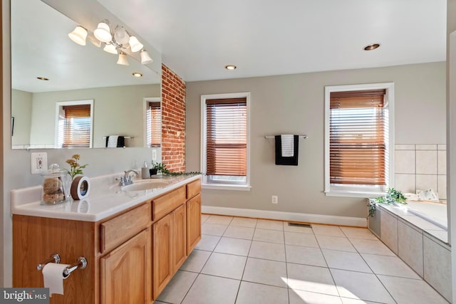 bathroom with tile patterned flooring, vanity, and tiled tub